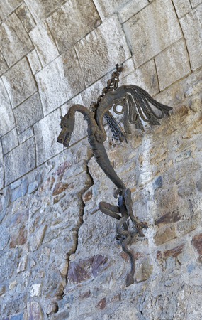 LJUBLJANA, SLOVENIA - SEPTEMBER 06, 2015: Steel gorgeous medieval mascot dragon in the form of a torch holder on the wall in the entry way to the Ljubljana Castle. Dragon is a symbol of Ljubljana.のeditorial素材