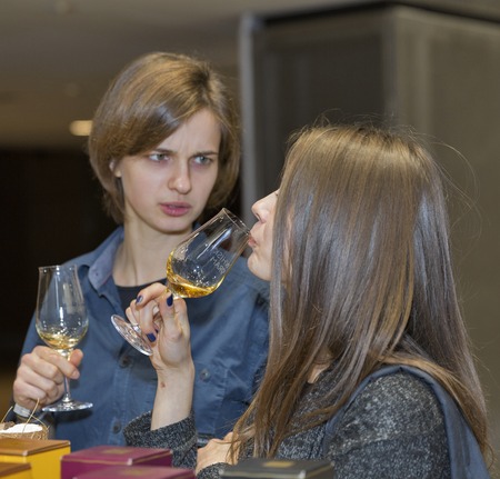 KIEV, UKRAINE - NOVEMBER 21, 2015: Unrecognized young visitors taste sample of Single Malt Scotch...