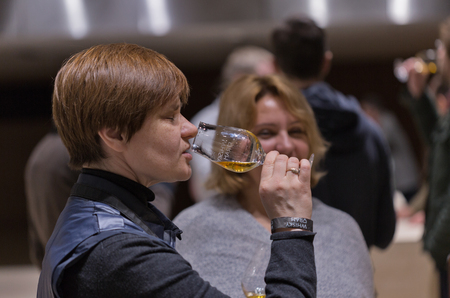 KIEV, UKRAINE - NOVEMBER 21, 2015: Unrecognized middle age visitor taste sample of Single Malt...