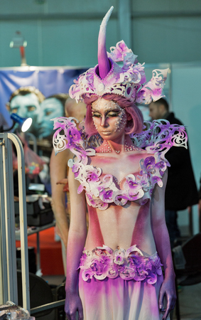 KIEV, UKRAINE - FEBRUARY 05, 2016: Girl in fantastic creature mask preparing for competition at Kyiv Fashion 2016 in KyivExpoPlaza exhibition center, 30th edition of International Vogue Festival.のeditorial素材