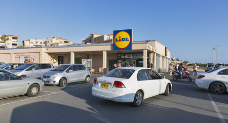 PAPHOS, CYPRUS - MAY 27, 2016: Unrecognized people go to Lidl supermarket with parking lot. Lidl is a German discount supermarket chain that operates over 7200 stores worldwide, it was founded in 1930のeditorial素材