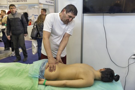 KIEV, UKRAINE - MARCH 25, 2016: Unrecognized man therapist demonstrates a massage treatments at 16th National Congress of Beauty Industry Estet Beauty Expo 2016 in IEC.のeditorial素材