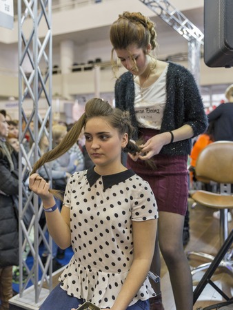 KIEV, UKRAINE - MARCH 25, 2016: Unrecognized woman hairdresser demonstrates her professional skills at 16th National Congress of Beauty Industry Estet Beauty Expo 2016 in IEC.のeditorial素材
