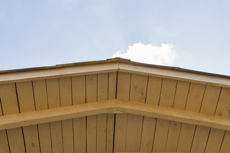 view of the construction of a pitched roof and sky with copy space