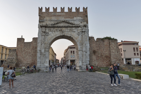 RIMINI, ITALY - SEPTEMBER 25, 2016: People in front of Arch of Augustus, ancient romanesque gate of the city - historical Italian landmark, the most ancient Roman arch that still stands intact.のeditorial素材