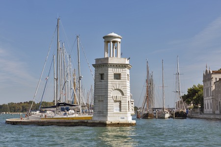 VENICE, ITALY - SEPTEMBER 23, 2016: Lighthouse and sailboat marina at San Giorgio Maggiore island in Venice lagoon. Venice is situated across a group of 117 islands that are separated by canals.のeditorial素材