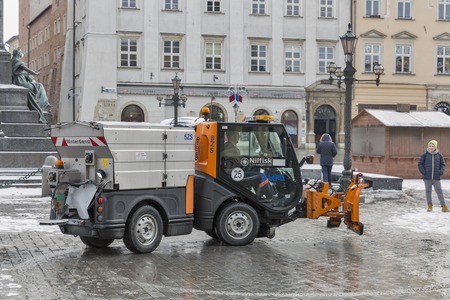 KRAKOW, POLAND - JANUARY 12, 2017: Unrecognized driver works on small snow blower truck on main city Market square ( Rynek Glowny ). Krakow is the second largest and one of the oldest cities in Polandのeditorial素材