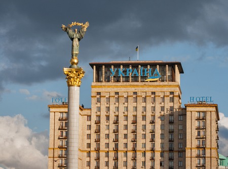 KIEV, UKRAINE - APRIL 05, 2015: Independence monument and Hotel Ukraina against stormy sky. This is a statue of an angel made of copper and gold plated standing on a tall pillar in the center of Kiev.のeditorial素材