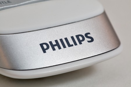KIEV, UKRAINE - APRIL 17, 2016: Logo Philips on modern smart TV remote control closeup on white....