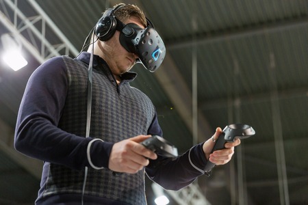 KIEV, UKRAINE - APRIL 07, 2017: Man use virtual reality game glasses and hand controlers at 2nd International Trade Show of Electric and Hybrid Vehicles Plug-In Ukraine in KyivExpoPlaza venue.のeditorial素材