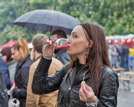 KIEV, UKRAINE - MAY 13, 2017: Unrecognized young woman taste wine during Kyiv Food and Wine Festival in National Expocenter, a permanent multi-purpose exhibition complex in the Teremky neighborhood.のeditorial素材