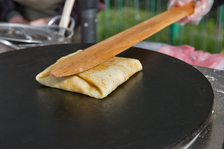 Making pancake with filling on frying electric stove outdoor closeupの写真素材