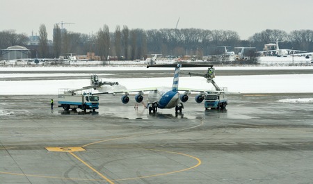 BORYSPIL, UKRAINE - FEBRUARY 08, 2015: Deicing treatment wing aircraft in Boryspil International Airport, the countrys largest airport serving over 8 million passengers per year.のeditorial素材