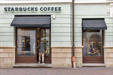 KRAKOW, POLAND - JANUARY 14, 2017: People visit Starbucks coffeehouse in Old Town. Starbucks Corporation is an American famous coffee company and coffeehouse chain.のeditorial素材