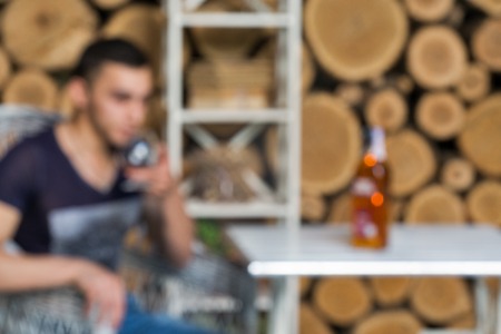 Abstract blurred young man with glass of whisky in a bar backgroundの写真素材