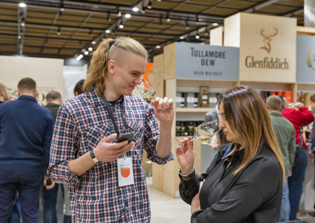 KIEV, UKRAINE - NOVEMBER 25, 2017: Unrecognized young people tasting Single Malt Scotch Whisky at 3rd Ukrainian Whisky Dram Festival in Parkovy Exhibition Center.のeditorial素材