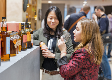 KIEV, UKRAINE - NOVEMBER 25, 2017: Unrecognized young woman visits Nikka Single Malt Whisky Japanese distillery booth at 3rd Ukrainian Whisky Dram Festival in Parkovy Exhibition Center.のeditorial素材