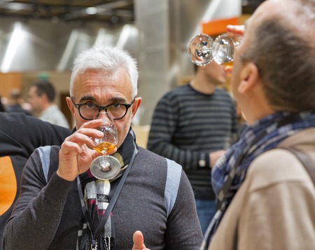 KIEV, UKRAINE - NOVEMBER 25, 2017: Unrecognized man tasting Single Malt Scotch Whisky at 3rd Ukrainian Whisky Dram Festival in Parkovy Exhibition Center.のeditorial素材