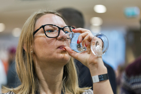 KIEV, UKRAINE - NOVEMBER 25, 2017: Unrecognized white middle aged woman tasting Single Malt Scotch Whisky at 3rd Ukrainian Whisky Dram Festival in Parkovy Exhibition Center.のeditorial素材