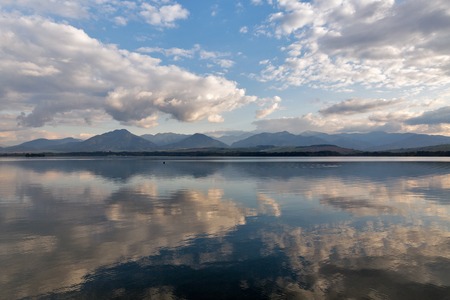 View over waters of Liptovska Mara lake with shore of Liptovsky Trnovec village and boats in Slovakia. Chocsky hills can be seen in the distance.の写真素材