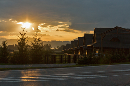wooden cottages town at dramatic sunsetの写真素材