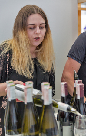 KIEV, UKRAINE - JUNE 02, 2018: Woman sommelier pours white wine at Kyiv Wine Festival booth. 77 winemakers from around the world took part big festival organized by Good Wine company.のeditorial素材