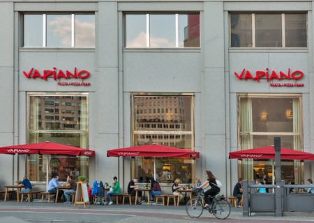 BERLIN, GERMANY - JULY 13, 2018: People enjoy food in Vapiano restaurant in downtown. It is a European restaurant franchise company established in 2002 in Hamburg and headquartered in Cologne.のeditorial素材