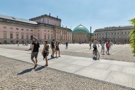 BERLIN, GERMANY - JULY 14, 2018: People walk along Bebelplatz square with State Opera, Hotel de Rome and St. Hedwig Cathedral. Berlin is the capital and German largest city by both area and population.のeditorial素材