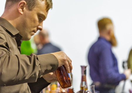 KIEV, UKRAINE - OCTOBER 20, 2018: Man sommelier pours Woodford bourbon whisky at booth of 4th...