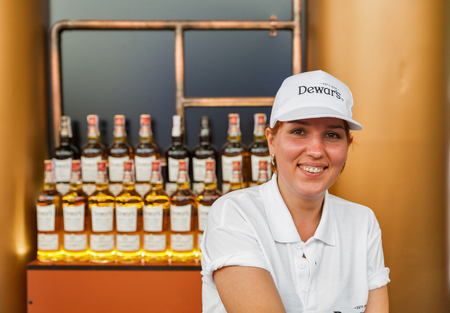 KIEV, UKRAINE - JULY 04, 2018: Dewar's blended Scotch whisky young woman bartender works in bar at the Atlas Weekend Festival in National Expocenter. It is world most awarded blended Scotch whisky.のeditorial素材