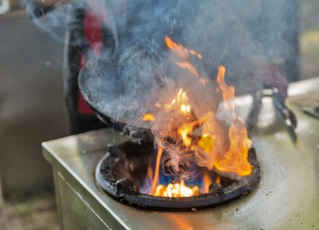 outdoor cooking asian food in a wok on the gas stove closeupの写真素材