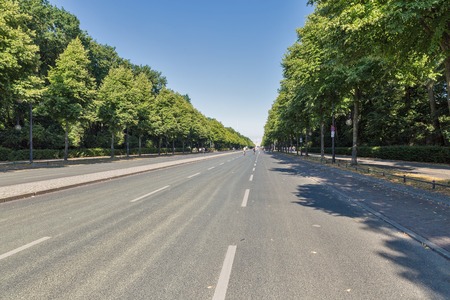 People walk along central street in summer Tiergarten Park, Berlin.の写真素材