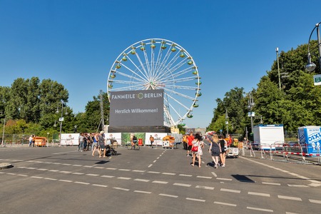 BERLIN, GERMANY - JULY 14, 2018: People visit football fan zone of FIFA World Cup 2018 in Tiergarten park close to Bgandenburg Gate. Berlin is the capital and largest city of Germany.