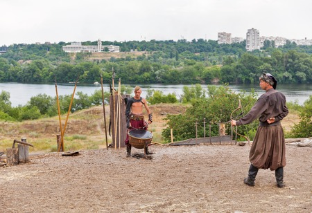 KHORTYTSIA, UKRAINE - JULY 03, 2018: Ukrainian Cossack shoots a bow in Zaporozhian Sich. It was inhabited by Cossacks who lived beyond the rapids of the Dnieper River in the 15th-18th century.のeditorial素材