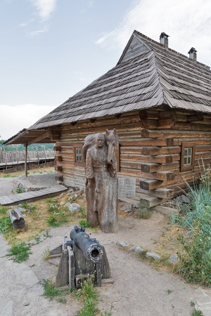 KHORTYTSIA, UKRAINE - JULY 03, 2018: Wooden statue of famous Ukrainian Cossack military leader Koshovyi Otaman Ivan Sirko. Buildings of Zaporozhian Host on island of Khortytsia.のeditorial素材