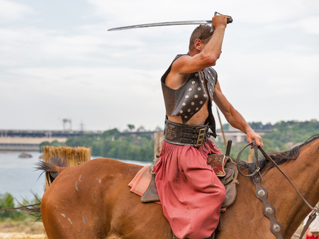 KHORTYTSIA, UKRAINE - JULY 03, 2018: Ukrainian Cossack horseman with saber in Zaporozhian Sich. It was inhabited by Cossacks who lived beyond the rapids of the Dnieper River in the 15th-18th century.のeditorial素材