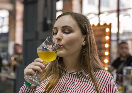 KYIV, UKRAINE - MAY 18, 2019: Young beautiful woman drink craft beer closeup during Kyiv Beer Festival vol. 4 in Art Zavod Platforma. More than 60 craft beer breweries were presented here.のeditorial素材