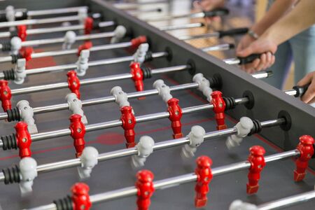 Young people playing foosball while resting indoors