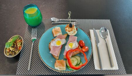 Breakfast with ham sandwiches, smoked salmon, bread, vegetables, bulgur rice salad and orange juice...