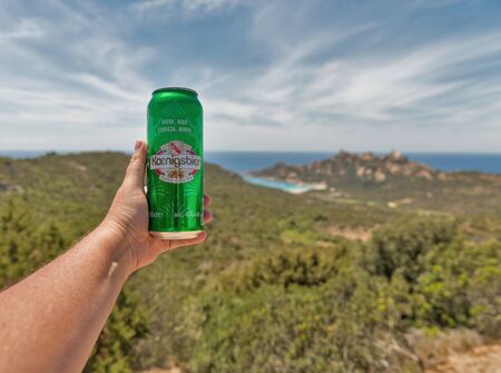 ROCCAPINA, CORSICA, FRANCE - JULY 17, 2019: White man's hand holds a can of Koenigsbier French beer...