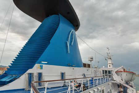 LIVORNO, ITALY - JULY 12, 2019: Early morning passengers have a rest on a deck of Moby Vincent ferry. It is an Italian shipping company that operates ferries between the Italiy or France and islands.のeditorial素材