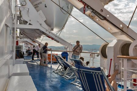 LIVORNO, ITALY - JULY 12, 2019: Passengers travel on the deck of Moby Vincent ferry ship at dawn,...