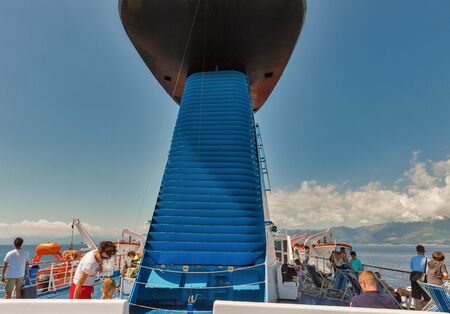 LIVORNO, ITALY - JULY 12, 2019: Passengers travel on the deck of Moby Vincent ferry ship,Corsica island in the background. Moby is an Italian shipping company that operates ferries.のeditorial素材