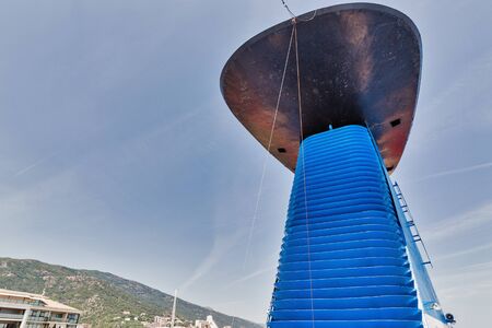 Cruise ship pipe close up against Bastia cityscape and clear blue sky background. Corsica island,...
