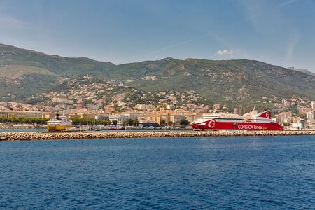 BASTIA, CORSICA, FRANCE - JULY 23, 2019: Cityscape with passenger port and moored ferry ships. Bastia port is the busiest French Mediterranean port.のeditorial素材