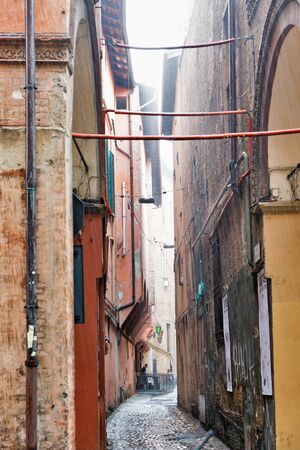BOLOGNA, ITALY - JULY 10, 2019: Ancient narrow street under heavy rain. Bologna is the seventh most populous city in Italy.のeditorial素材