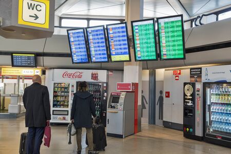 BERLIN, GERMANY - OCTOBER 18, 2019: Passengers look at the timetable schedule board in Tegel Airport, the main international airport of the capital of Germany.