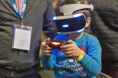KYIV, UKRAINE - APRIL 06, 2019: Boy in virtual reality glasses plays computer game at booth during...