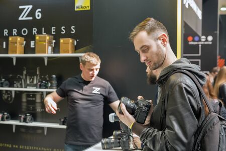KYIV, UKRAINE - APRIL 06, 2019: Young people testing professional photographic cameras on Nikon booth during CEE 2019, the largest electronics trade show of Ukraine in Tetra Pack EC.のeditorial素材
