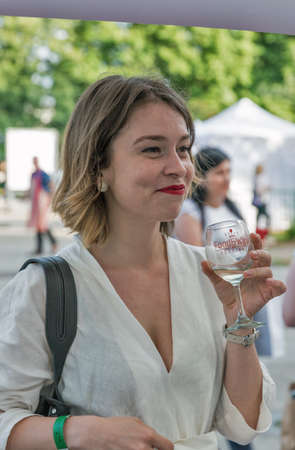 KYIV, UKRAINE - MAY 19, 2018: Woman tasting wine at winery booth during Food and Wine Festival in National Expocenter, a permanent multi-purpose exhibition complex.のeditorial素材